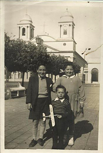 Juan Policicchio con sus hermanos en la plaza de Morón en 1950. Se puede apreciar que las cíºpulas de la catedral no son las mismas de hoy en dí­a. 